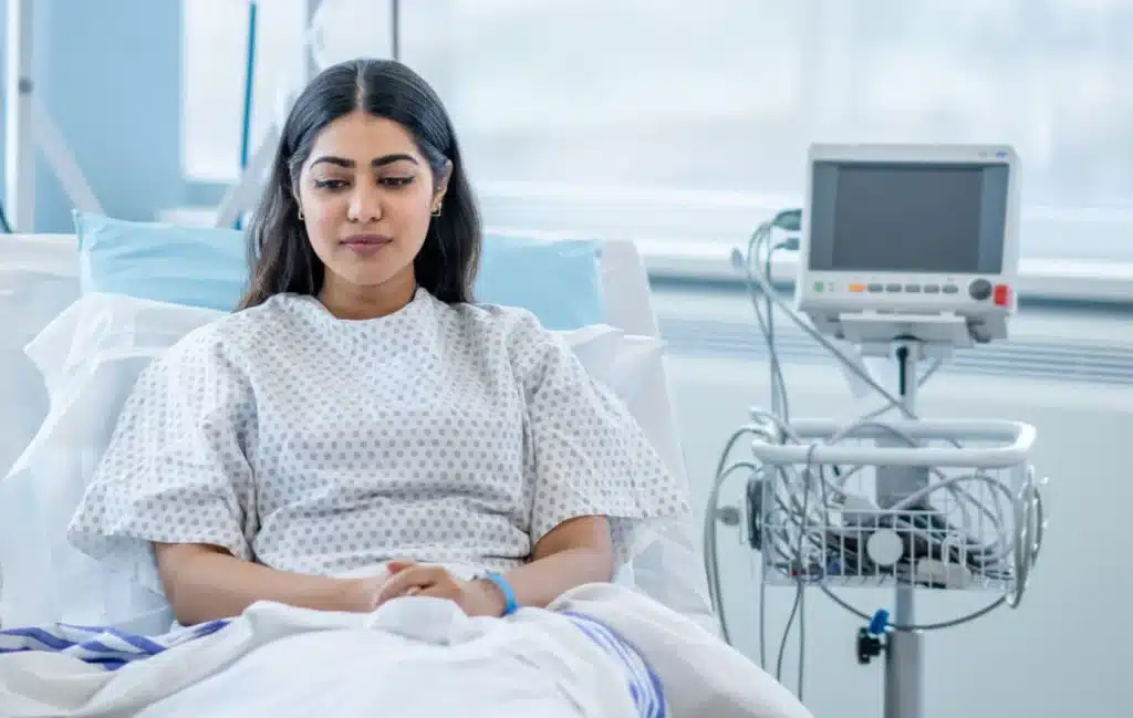 A woman reclines in her hospital bed