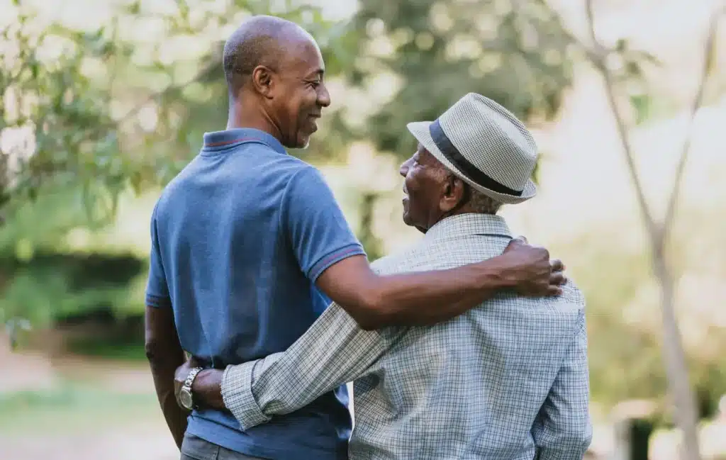 Two men smile and wrap their arms around each other