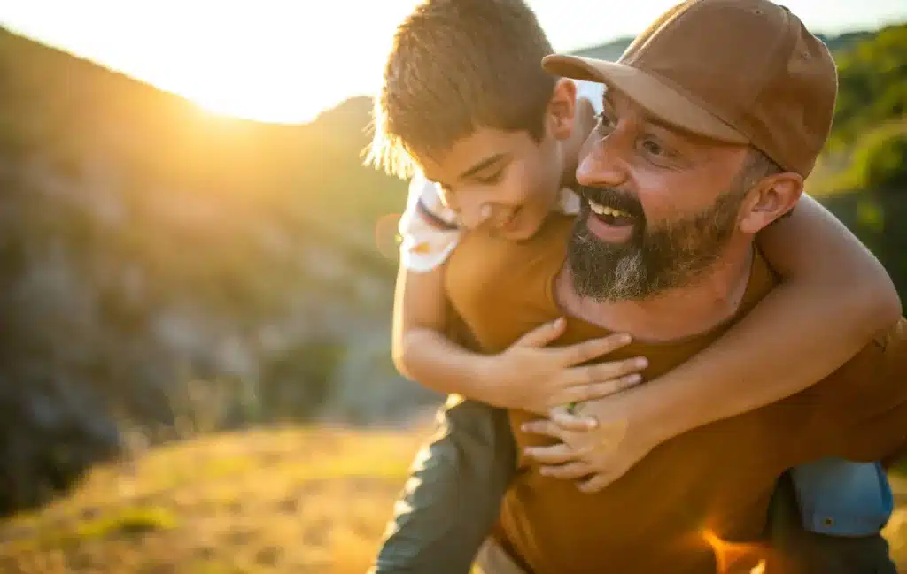 A father gives his son a piggyback ride.