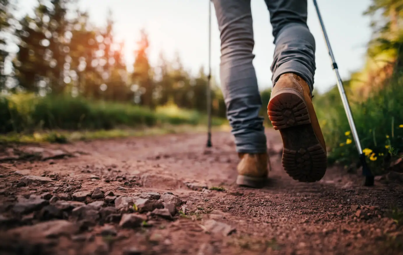 Closeup of a person's hiking boots walking on a trail