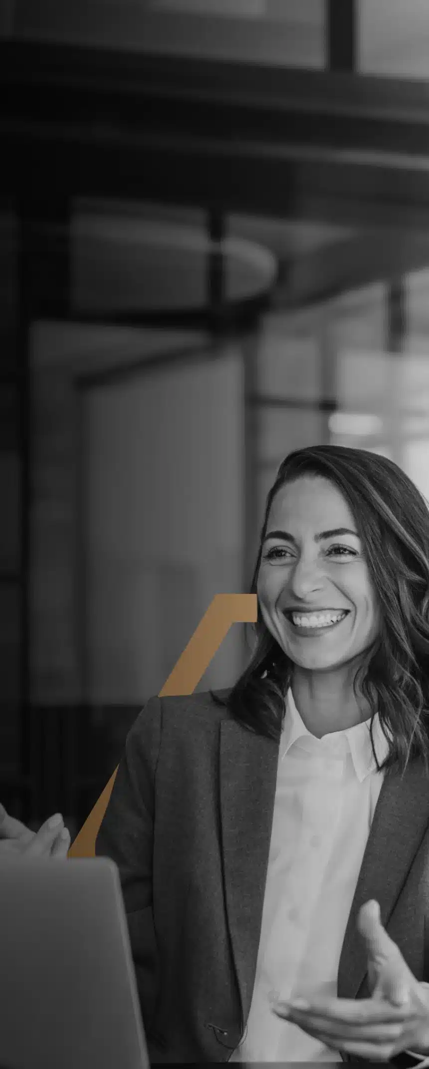 A business woman working on a laptop and smiling.