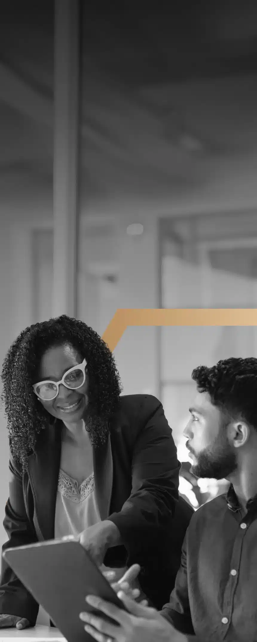 A woman consults with a man while looking at a tablet.