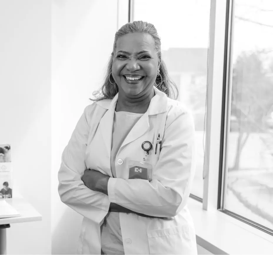 A physician smiles with her arms crossed.