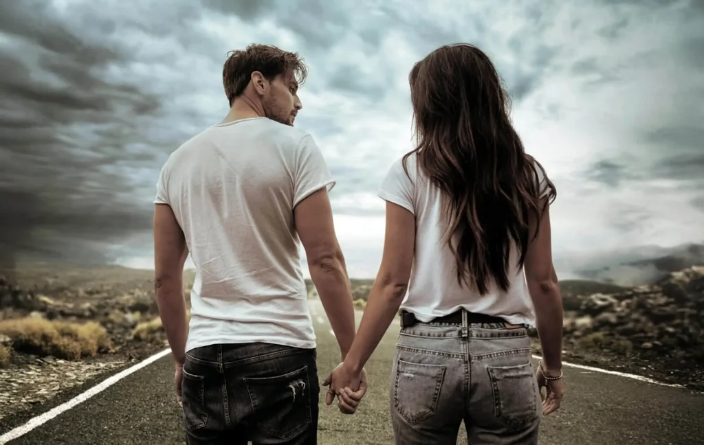 A couple walking on the road and holding hands.