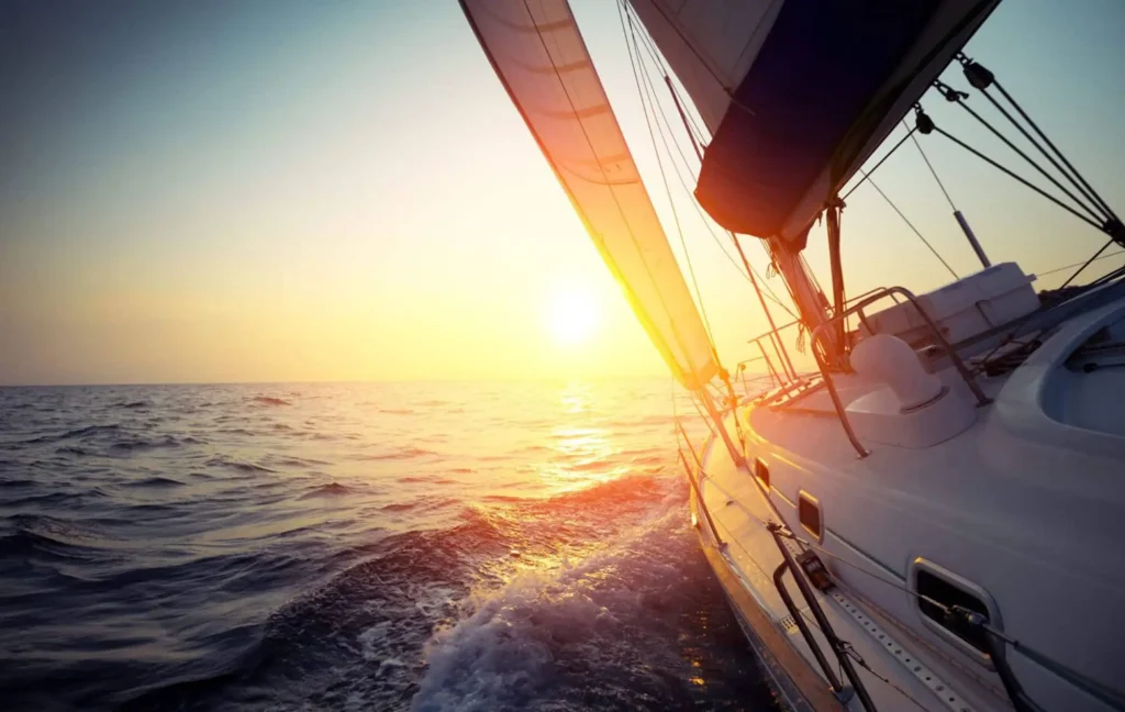 Boat sailing with the sunset on the horizon.