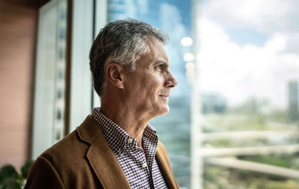 A man gazes out a window.
